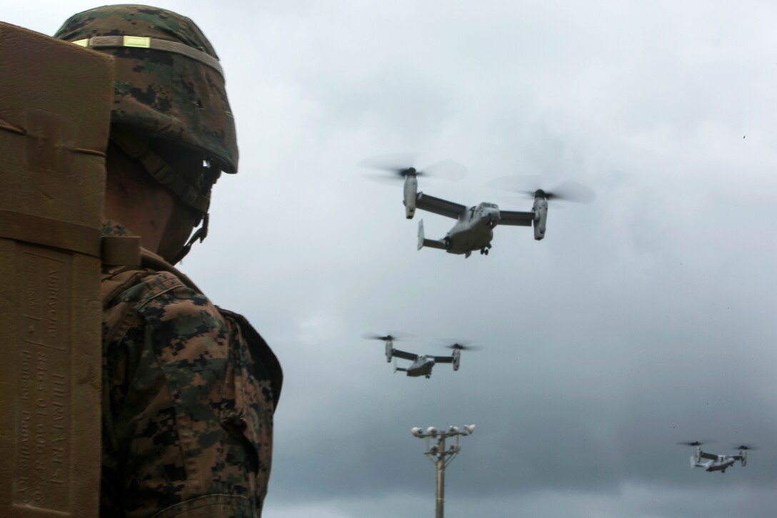 U.S. Marine Corps Lance Cpl. Andy Tam watches as a group of MV-22B Ospreys approach the landing zone on Camp Hansen, Okinawa, Japan, Oct. 31, 2015, to pick up Marines for an air assault exercise. Tam is assigned to the 2nd Marine Division's 1st Battalion, 2nd Marine Regiment, 2nd Marine Expeditionary Force. U.S. Marine Corps photo by Cpl. Drew Tech
