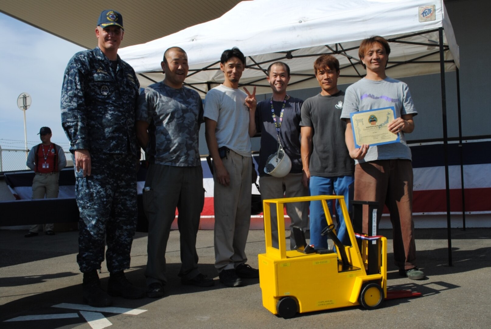 DLA Distribution Yokosuka's Transportation Division is awarded first place in the annual Forklift Rodeo. The award was presented by the distribution center's commander Navy Cmdr. Brian Johnson, left.