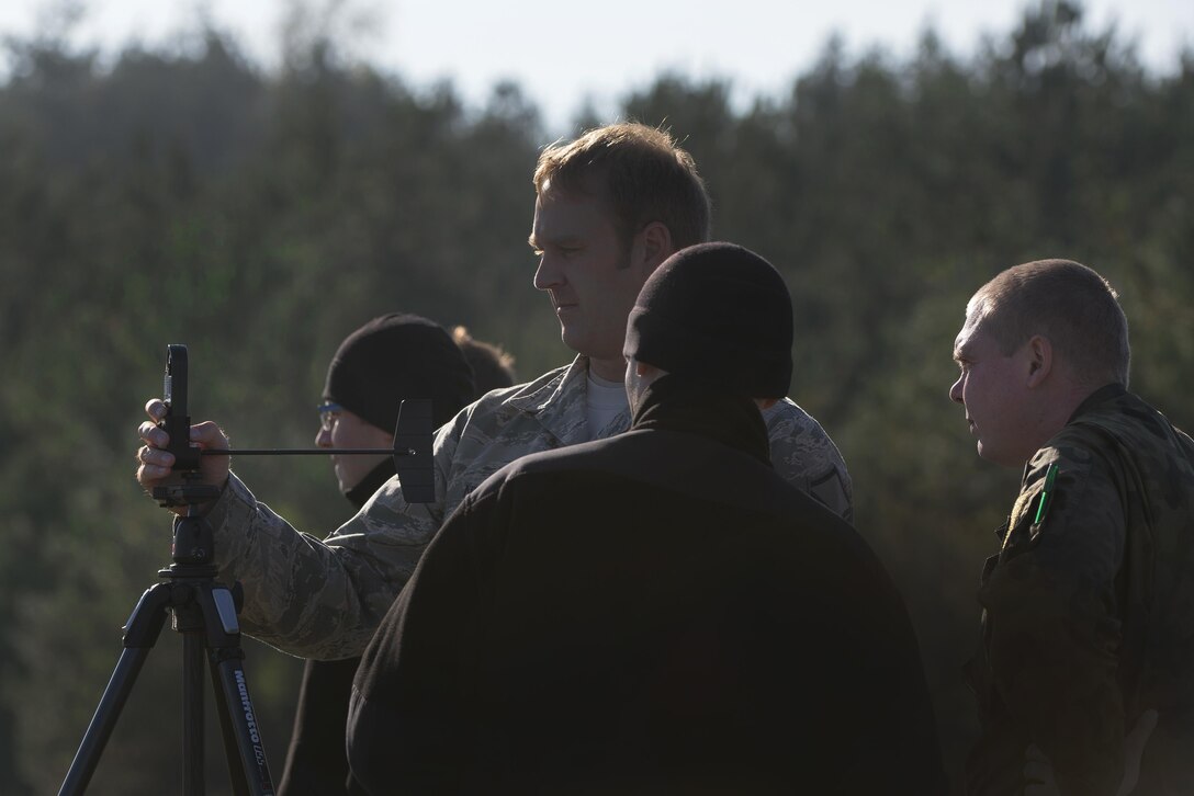 U.S. Air Force Master Sgt. Stephen Nelson, center, uses a kestrel weather tracker to obtain wind speeds and direction during Aviation Detachment 16-1, an exercise on Powidz Air Base, Poland, Oct. 27, 2015. Nelson is an air traffic controller assigned to the 435th Contingency Response Group.

