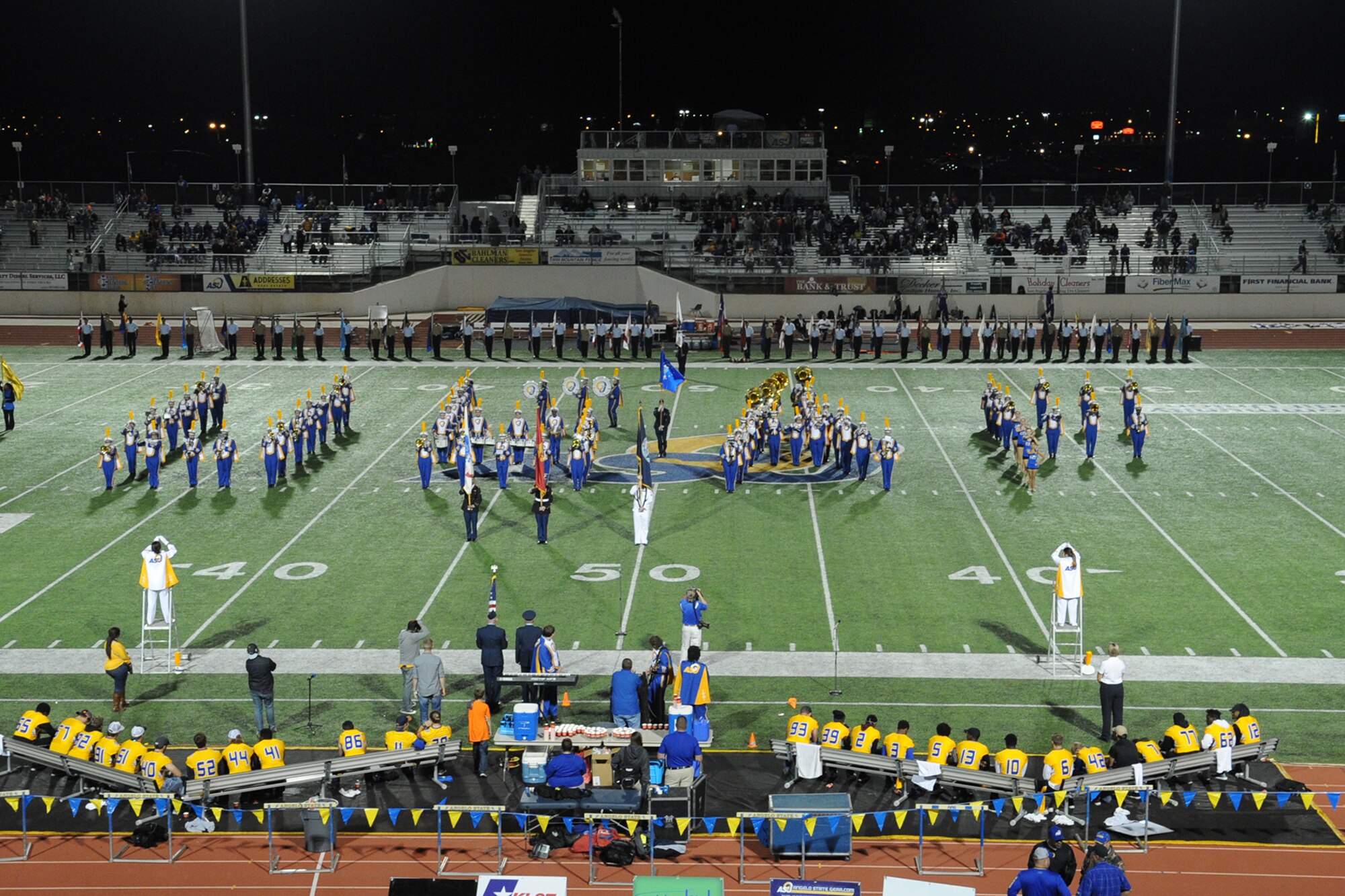 The Angelo State University marching band performs the Air Force song and forms the letters USAF as an Airman presents the Air Force flag during ASU’s Military Appreciation Day football game half-time show at the LeGrand Stadium, San Angelo, Texas, Oct. 31, 2015. The band also formed ARMY, USMC, NAVY and USCG as they played each branch’s service song. (U.S. Air Force photo by Staff Sgt. Laura R. McFarlane/Released)