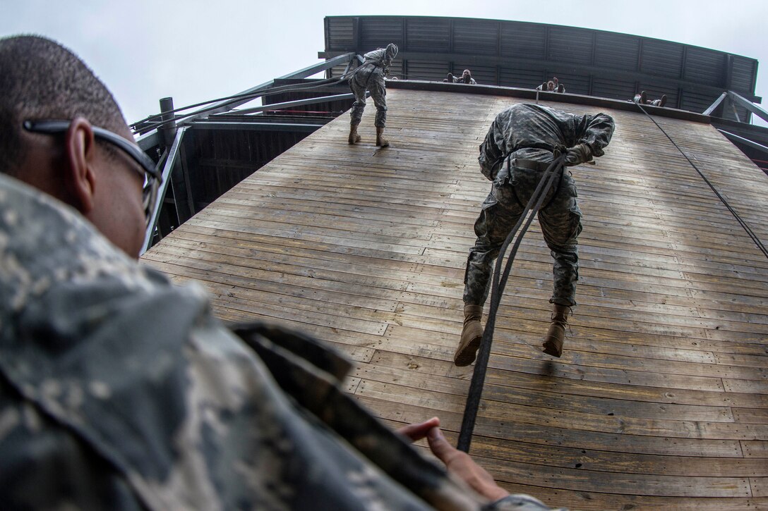 Soldiers stand ready on belay on a rainy fall morning for soldiers rappelling down the 40-foot wall at Victory Tower on Fort Jackson, S.C., Oct. 28, 2015. The soldier is assigned to Company E, 2nd Battalion, 39th Infantry Regiment. U.S. Army photo by Sgt. 1st Class Brian Hamilton



