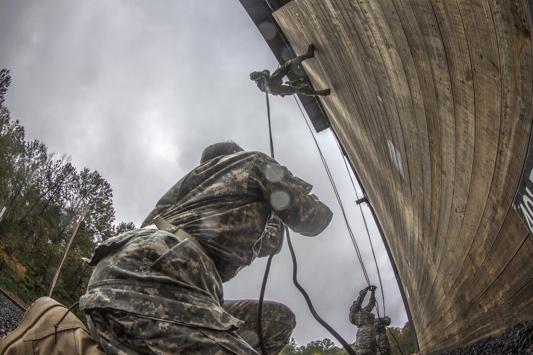 Army Pvt. Alisa Hamilton, foreground, stops a soldier rappelling down the 40-foot wall from falling at Victory Tower on Fort Jackson, S.C., Oct. 28, 2015. Hamilton is assigned to Company E, 2nd Battalion, 39th Infantry Regiment. U.S. Army photo by Sgt. 1st Class Brian Hamilton