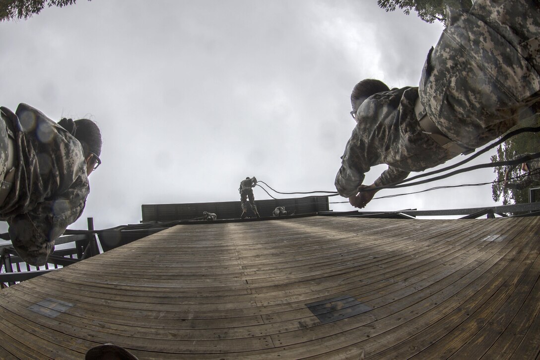 Soldiers stand ready on belay on a rainy fall morning as soldiers rappel down the 40-foot wall at Victory Tower on Fort Jackson, S.C., Oct. 28, 2015. U.S. Army photo by Sgt. 1st Class Brian Hamilton