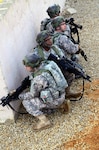 A group of Georgia National Guard Soldiers stack behind a wall during the cordon and search lane at the Joint Multinational Readiness Center in Hohenfels, Germany Nov. 7, 2011. National Guard Soldiers from several states - including the Wisconsin Army National Guard's 157th Maneuver Enhancement Brigade - are part of the KFOR 15 rotation preparing to deploy to Kosovo in the upcoming months.