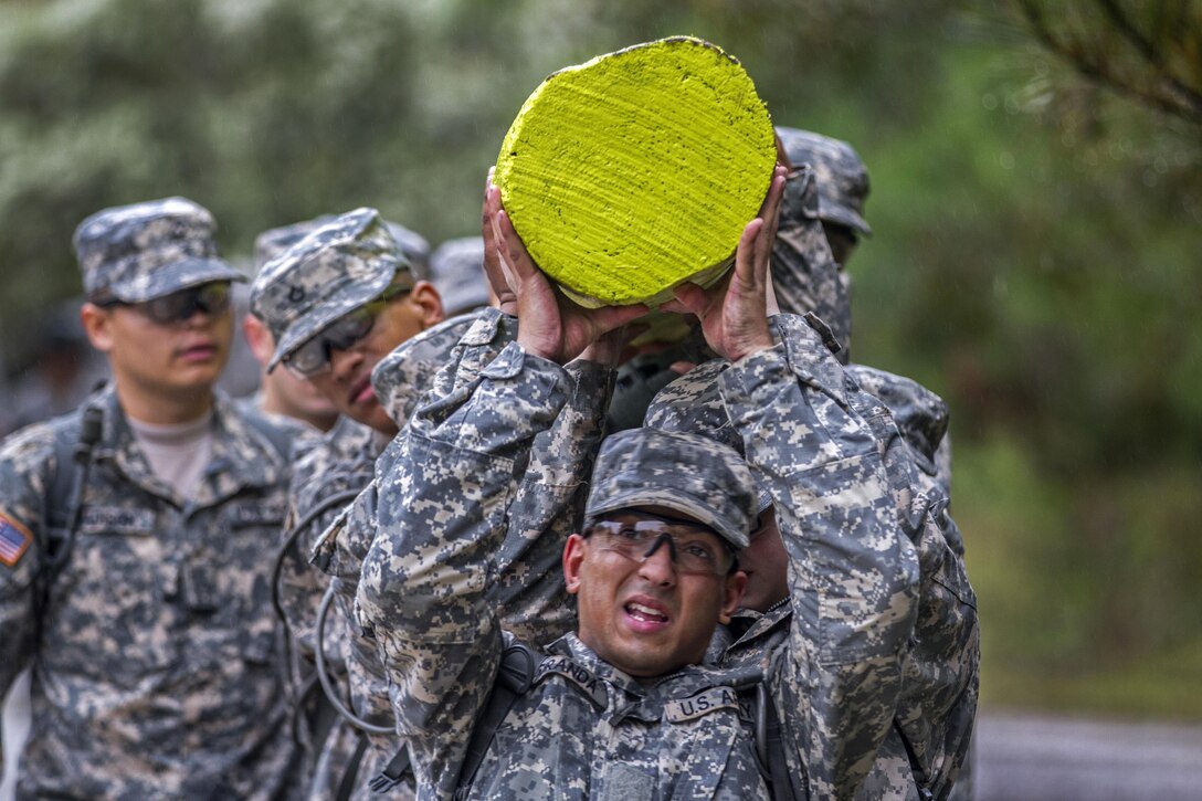 Soldiers use teamwork to switch shoulders while carrying a log at Victory Tower on Fort Jackson, S.C., Oct. 28, 2015. U.S. Army photo by Sgt. 1st Class Brian Hamilton