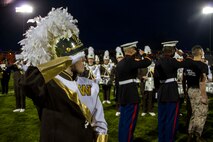 A Drum Major from Bay City Western High School, Staff Sgt. Luke DeJong and Sgt. Christopher Parker from Recruiting Sub Station Saginaw, Mich., salute the flag during the National Anthem before the start of the Great American Rivalry Series game between Bay City Central and Bay City Western high schools, Oct. 23, 2015. The Great American Rivalry Series games allowed Marines, football players and the school’s student body to interact over a relatable common ground topic: competition. 