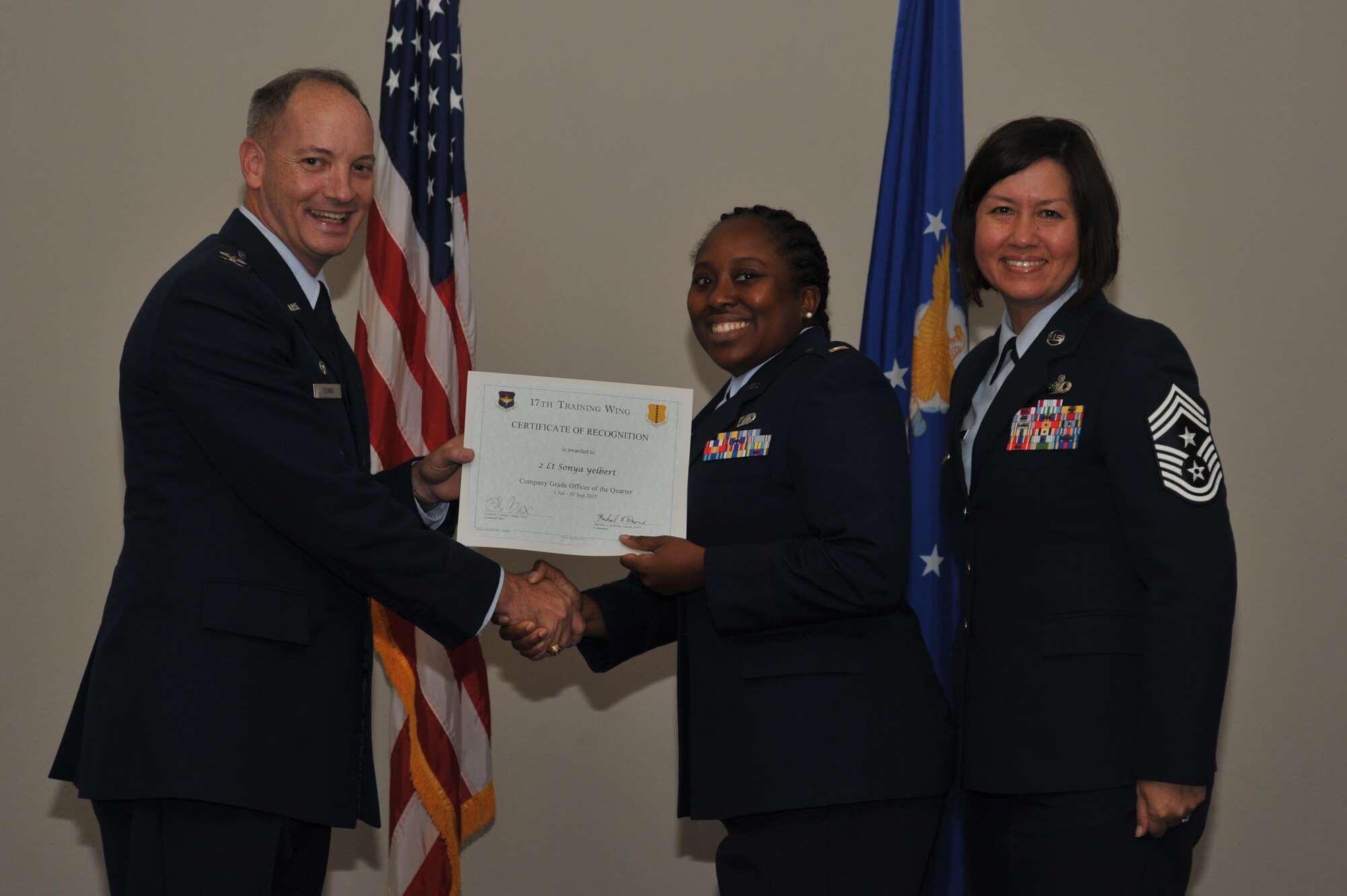 U.S. Air Force Col. Michael L. Downs, 17th Training Wing Commander, and Chief Master Sgt. JoAnne S. Bass, 17th TRW Command Chief, present the Company Grade Officer of the Quarter Award to 2nd Lt. Sonya Yelbert, 17th Medical Group, during the wing quarterly awards ceremony at the Event Center on Goodfellow Air Force Base, Texas, Oct. 30, 2015. (U.S. Air Force photo by Airman Chase Sousa/Released)