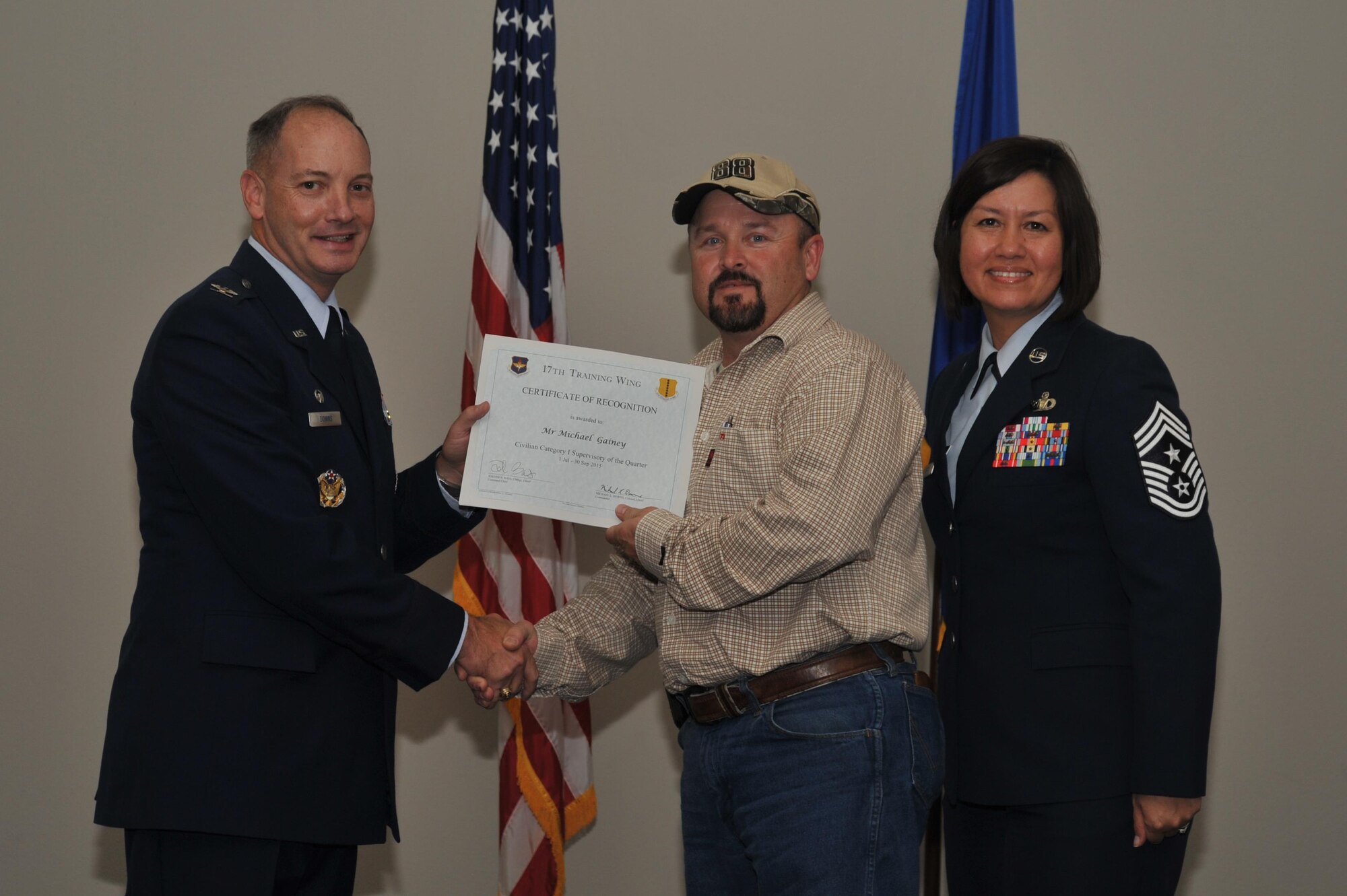 U.S. Air Force Col. Michael L. Downs, 17th Training Wing Commander, and Chief Master Sgt. JoAnne S. Bass, 17th TRW Command Chief, present the Civilian Category I Supervisory of the Quarter Award to Michael Gainey, 17th Mission Support Group, during the wing quarterly awards ceremony at the Event Center on Goodfellow Air Force Base, Texas, Oct. 30, 2015. (U.S. Air Force photo by Airman Chase Sousa/Released)