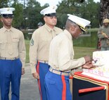 Installation officials, Marines, civilian-Marines and personnel from Marine Corps Logistics Base Albany’s tenant commands gather for a morning of pageants, Corps' history and cake-cutting in celebration of the Marine Corps’ 240th birthday, here, Nov. 3. The annual commemoration, which was held at the Amphitheater in Boyett Park/Covella Pond, featured Marines dressed in an array of uniforms and carrying weapons from specific eras, past to present, during a narration of the Marine Corps’ 240-year history. Col. James C. Carroll III, commanding officer, MCLB Albany, cut the traditional birthday cake and presented a slice to the installation’s oldest serving Marine present at the ceremony, Lt. Col. Walter Wilkie, who passed it to the youngest Marine present, Lance Cpl. Alandre Brown. The passing of the cake from the oldest to the youngest Marine symbolizes the passing of history and traditions to the next generation.
