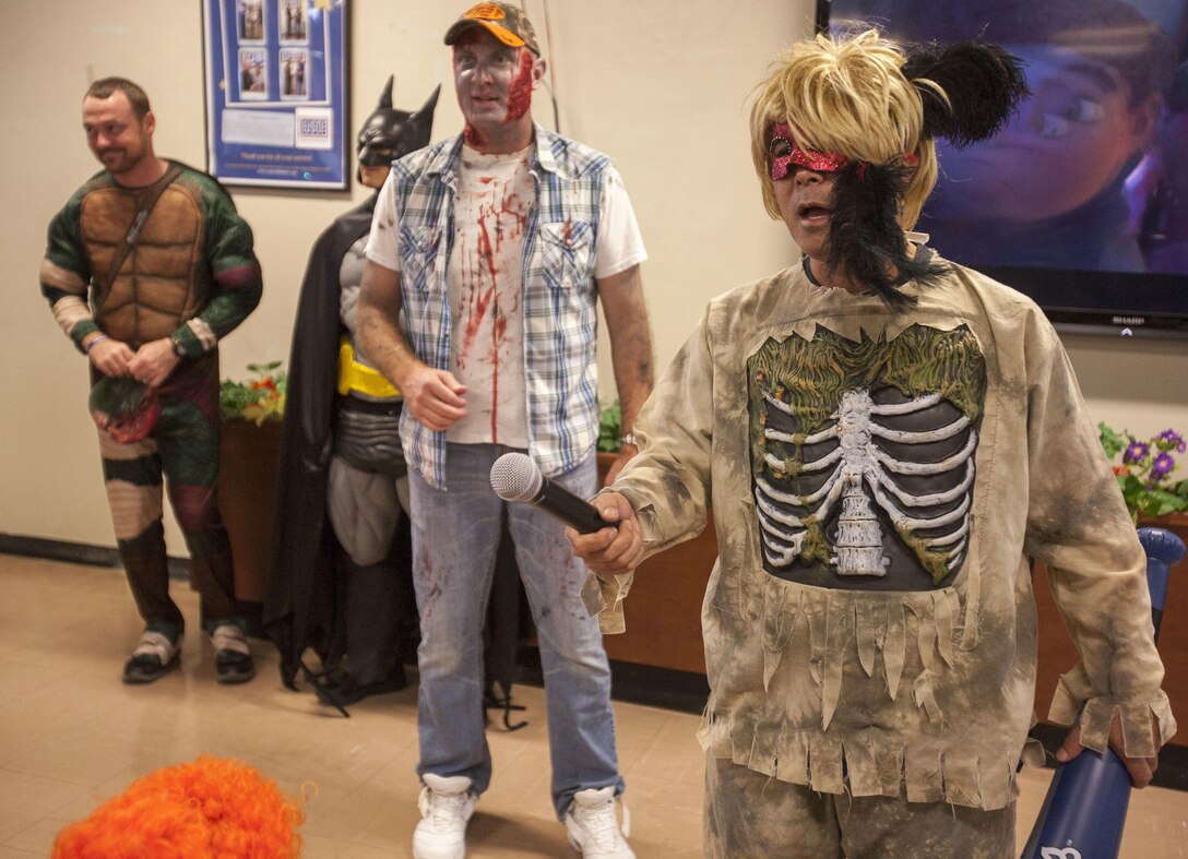 Fumi Iha, right, and Lt. Col. Jim Sweeney, center, give opening remarks at the Trunk-or-Treat event on Camp Schwab, Okinawa, Japan, on Oct. 31. This was the first year a Halloween event was held on base for the members of the Okinawa community. There was food, candy and face painting at the event. U.S. Marines are good neighbors who are engaged with and contribute to Okinawa communities. Iha is the community relationship specialist for Camp Schwab. Sweeney, from Omaha, Nebraska, is the executive officer with 4th Marine Regiment, 3rd Marine Division, III Marine Expeditionary Force.