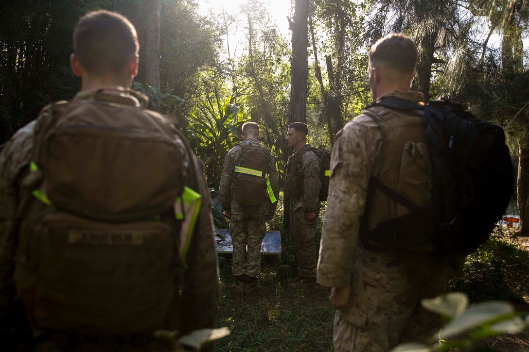 Sgt. Codi R. Quevedo reads aloud the story of a Medal of Honor recipient, Pvt. Dale M. Hansen, during the Air Naval Gunfire Liaison Company Basic Course at the endurance course on Camp Hansen, Okinawa, Japan, Oct. 19, 2015.  The Marines stopped at various stations throughout the course where they engaged in exercises to the honor Medal of Honor recipients. Quevedo from Aztec, New Mexico, is a field radio operator with 2nd Brigade 5th ANGLICO, III Marine Expeditionary Force Headquarters Group, III MEF.