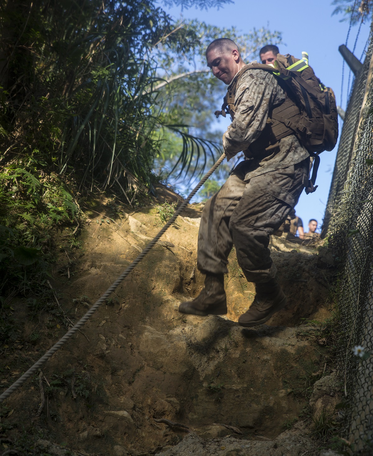 Lance Cpl. Jeremiah E. Day climbs down a cliff in the Medal of Honor Endurance Course during the Air Naval Gunfire Liaison Company Basic Course on Camp Hansen, Okinawa, Japan, Oct. 19, 2015. The Marines stopped at various stations throughout the course where they engaged in exercises to the honor Medal of Honor recipients. The ANGLICO Basic Course is a seven-week course that provides ANGLICO Marines the basic training and skill level needed to complete their mission. As part of the course, the Marines begin with physical training including ground fighting, runs with backpacks and completing an obstacle course. Day from Amarillo, Texas, is a field radio operator with 5th ANGLICO, III Marine Expeditionary Force Headquarters Group, III MEF.