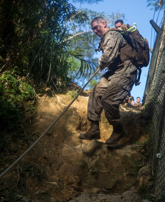 Lance Cpl. Jeremiah E. Day climbs down a cliff in the Medal of Honor Endurance Course during the Air Naval Gunfire Liaison Company Basic Course on Camp Hansen, Okinawa, Japan, Oct. 19, 2015. The Marines stopped at various stations throughout the course where they engaged in exercises to the honor Medal of Honor recipients. The ANGLICO Basic Course is a seven-week course that provides ANGLICO Marines the basic training and skill level needed to complete their mission. As part of the course, the Marines begin with physical training including ground fighting, runs with backpacks and completing an obstacle course. Day from Amarillo, Texas, is a field radio operator with 5th ANGLICO, III Marine Expeditionary Force Headquarters Group, III MEF.