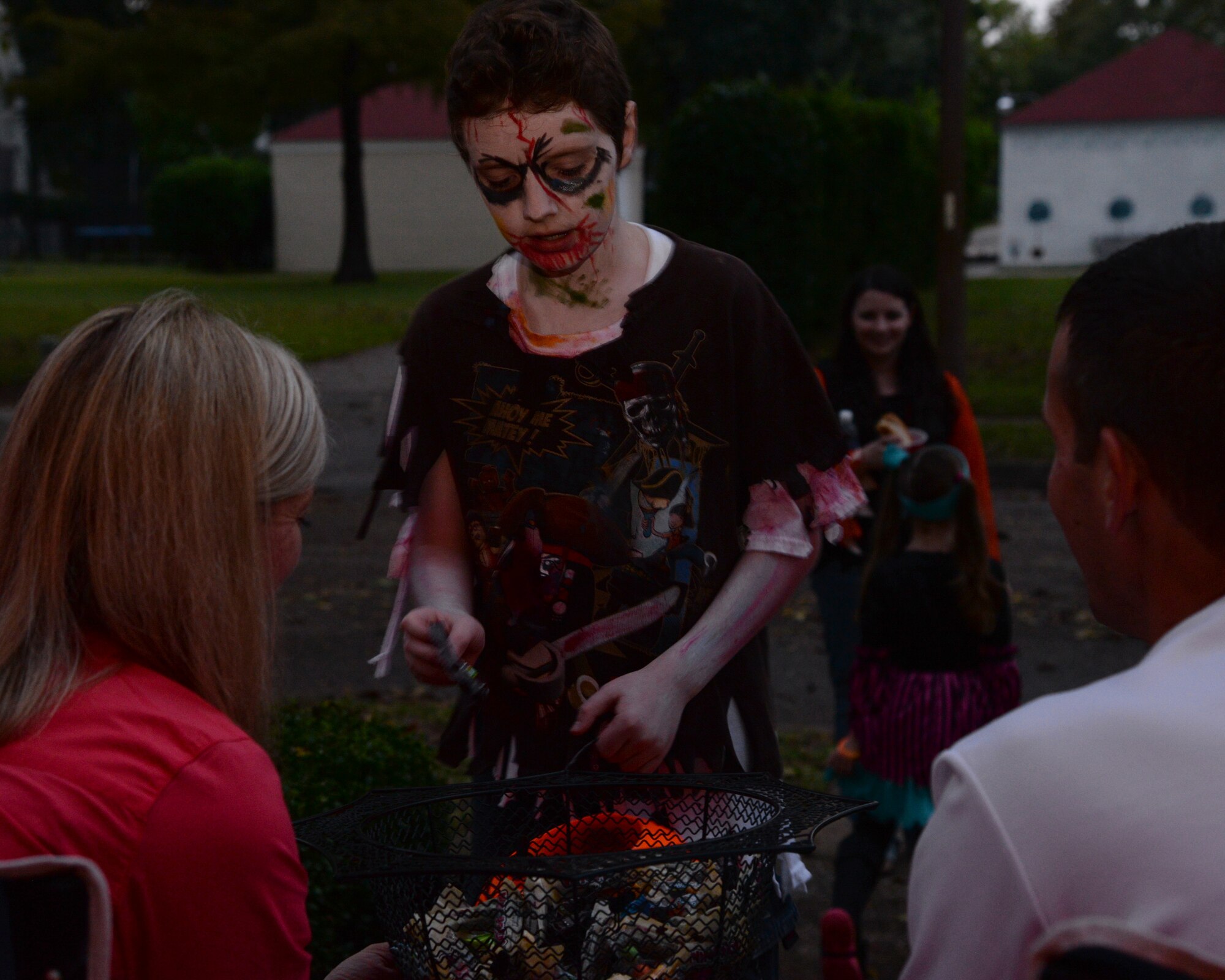 A costumed child receives candy from Barksdale residents while trick-or-treating at Barksdale Air Force Base, La., Oct. 31, 2015. Airmen and their families passed out candy throughout the night. (U.S. Air Force photo/ Senior Airman Jannelle Dickey)