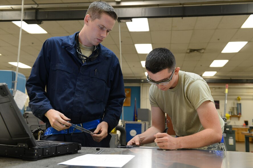 Staff Sgt. Eric Olson, 56th Equipment Maintenance Squadron aircraft structural maintenance craftsman, works with Airman 1st Class Joshua Perry, 56th EMS aircraft structural maintenance apprentice, to copy a blueprint onto a sheet of metal at Luke Air Force Base, Arizona, Oct. 30, 2015. (U.S. Air Force photo by Senior Airman James Hensley) 