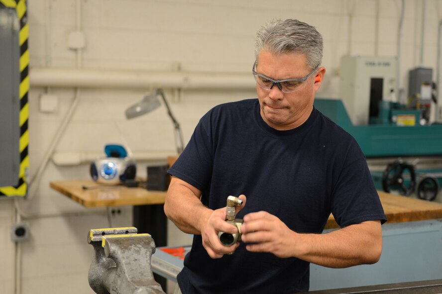 Craig Trujillo, 56th Equipment Maintenance Squadron civilian machinist, modifies a hydraulic test stand part at Luke Air Force Base, Arizona, Oct. 30, 2015. The part is for a Singaporean hydraulic test stand which needed to be converted from metric to U.S. customary. (U.S. Air Force photo by Senior Airman James Hensley)