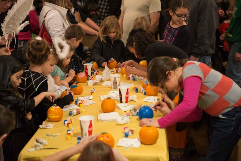 Icemen and their families paint pumpkins in the Yukon Club during the Fall Festival on Oct. 28, 2015, at Eielson Air Force Base, Alaska. The Fall Festival kicked off the “Winter-vention” campaign created by the 354th Force Support Squadron to help get Airmen and their families out and about throughout the winter. (U.S. Air Force photo by Staff Sgt. Joshua Turner/Released)