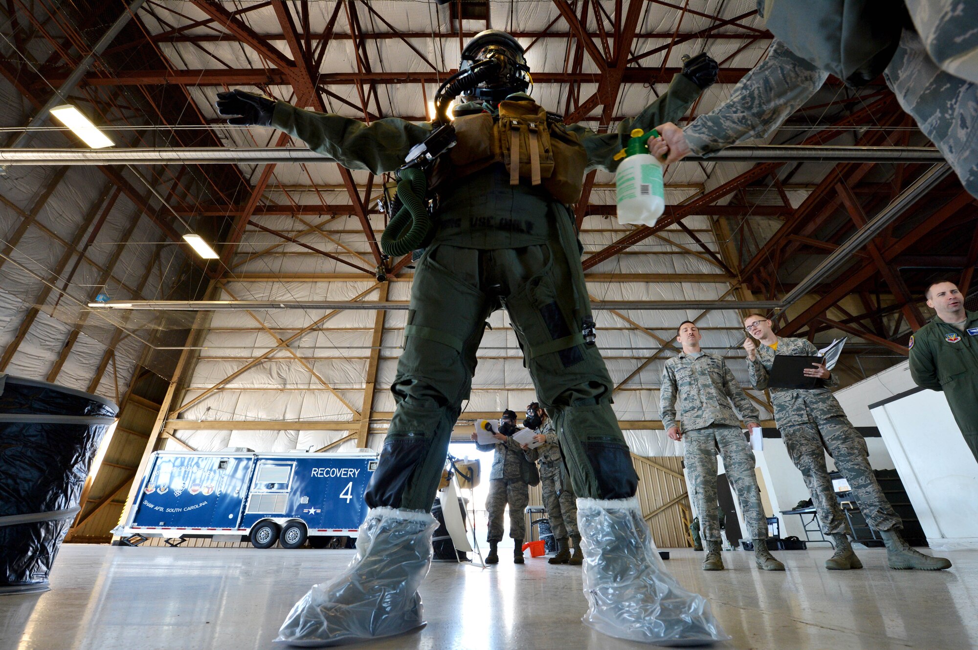 A 20th Operations Support Squadron aircrew flight equipment specialist simulates spraying 1st Lt. Chris Brown, 77th Fighter Squadron F-16CM Fighting Falcon pilot, during aircrew flight equipment decontamination training at Shaw Air Force Base, S.C., Oct. 23, 2015. After possible contamination exposure, Aircrew are escorted through four decontamination stations to safely remove all clothing and equipment. (U.S. Air Force photo by Senior Airman Diana M. Cossaboom/Released)