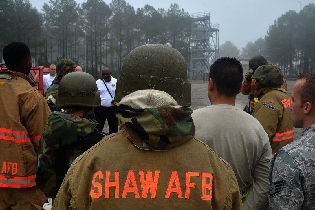 U.S. Air Force firefighters assigned to the 20th Civil Engineer Squadron, receive feedback after responding to a simulated aircraft crash during operational readiness exercise Weasel Victory 16-02 at Shaw Air Force Base, S.C., Nov. 2, 2015. The 20th CES fire department must respond to an incident within seven minutes of the initial call as part of the training conditions in various scenarios during the exercise. (U.S. Air Force photo by Senior Airman Michael Cossaboom/Released)