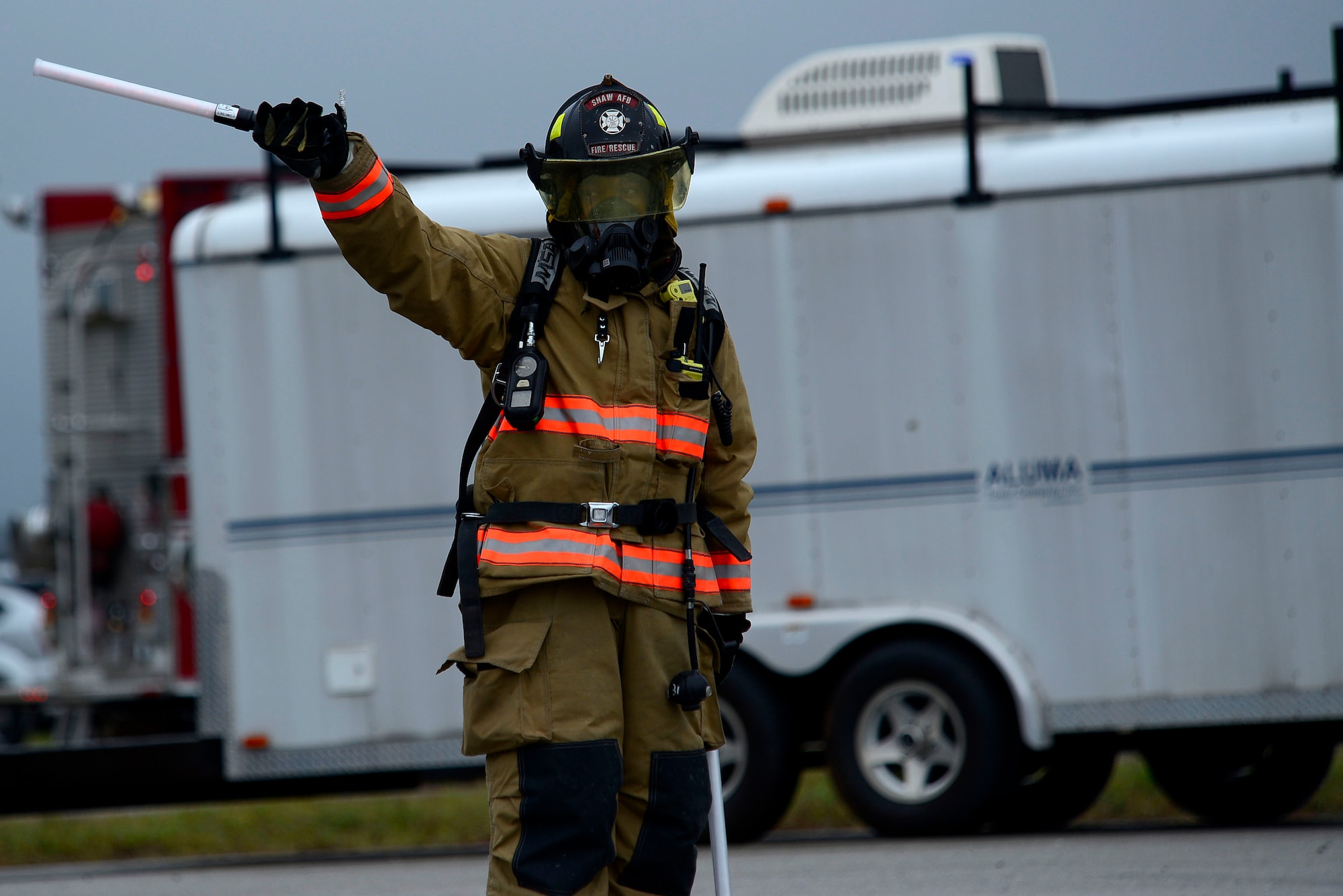 A 20th Civil Engineer Squadron firefighter signals firefighters operating a BAK-12 aircraft arresting system during operational readiness exercise Weasel Victory 16-02 at Shaw Air Force Base, S.C., Nov. 2, 2015. During the second phase of the exercise, firefighters are tasked with performing their duties while in a simulated deployed environment. (U.S. Air Force photo by Airman 1st Class Christopher Maldonado/Released)