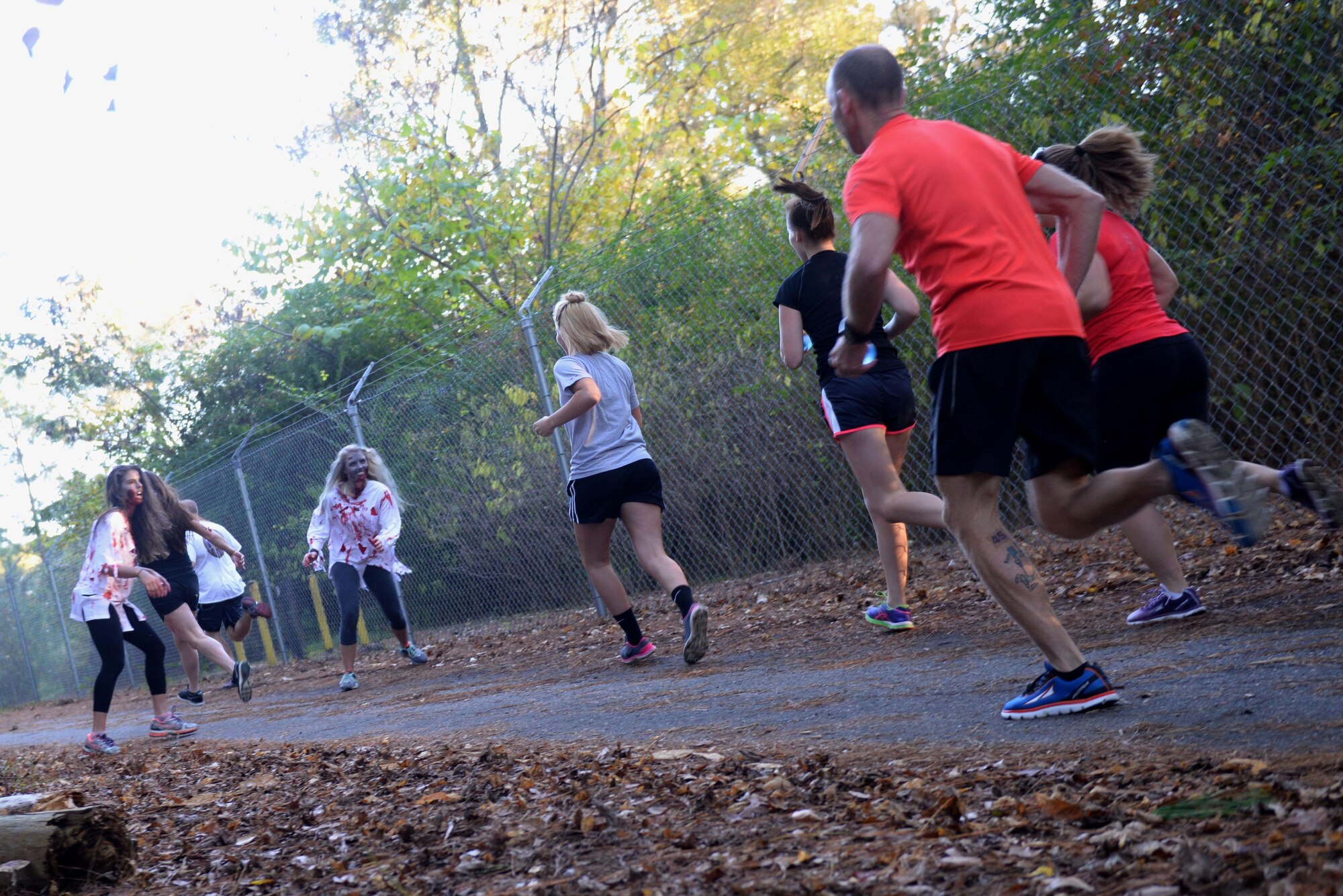 Runners encounter zombies during the Zombie 5K, Oct. 30, 2015, at Seymour Johnson Air Force Base, North Carolina. All along the running trail, zombies were placed to scare and sprint after the runners taking part in the 5K. (U.S. Air Force photo/Airman 1st Class Ashley Williamson)