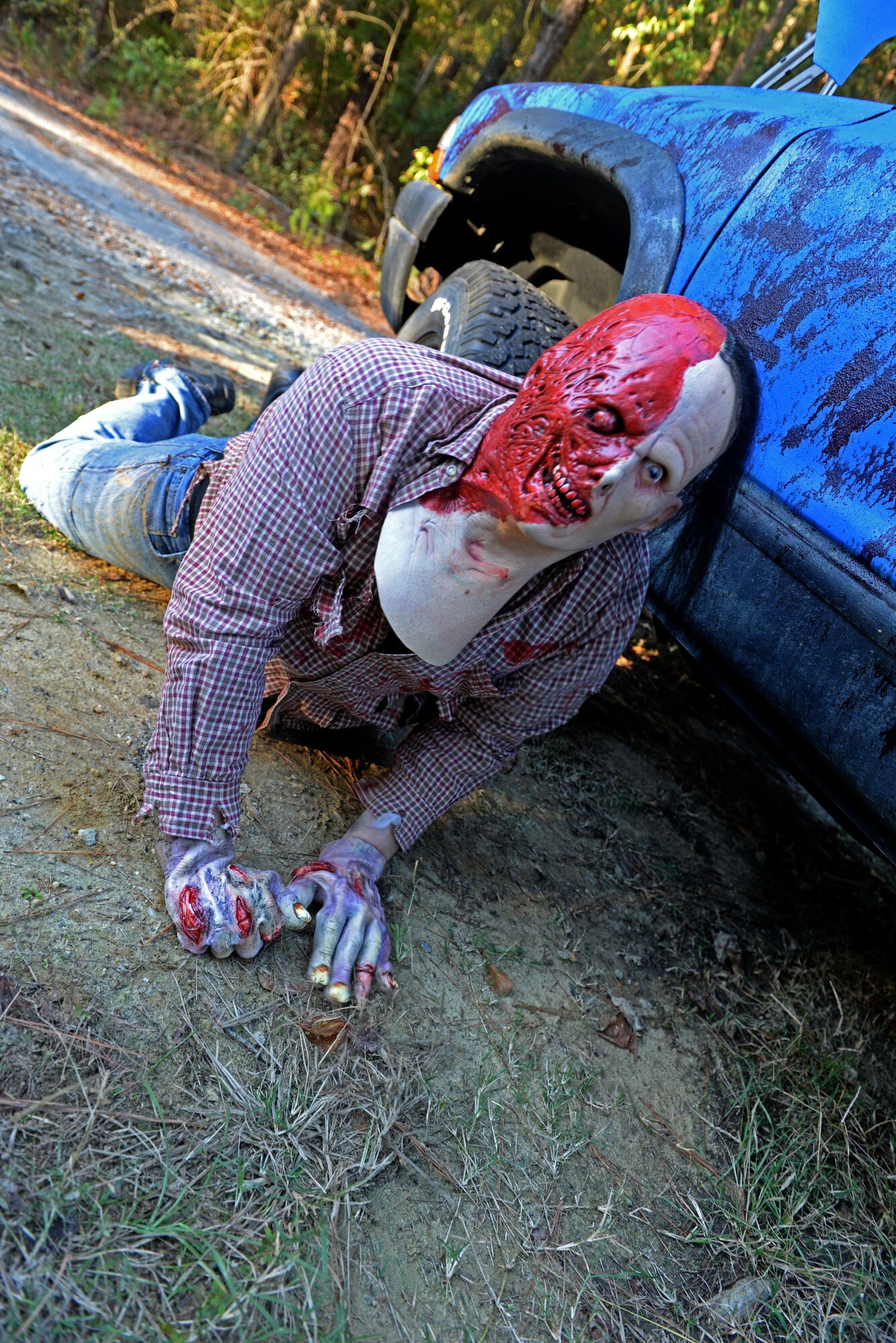 Tech. Sgt. John Parker, 4th Contracting Squadron contracting officer, acts like a zombie during the Zombie 5K, Oct. 30, 2015, at Seymour Johnson Air Force Base, North Carolina. Parker assisted in setting up the running trail and applied zombie makeup to all of the volunteers for the Zombie 5K. (U.S. Air Force photo/Airman 1st Class Ashley Williamson)