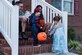 Members of Team Seymour hand out candy to a pair of trick-or-treaters, Oct. 31, 2015, at Seymour Johnson Air Force Base, North Carolina. From spooky to sparkly, members of Team Seymour took to base housing in their best costumes looking to scare and score treats. (U.S. Air Force photo/Airman Shawna L. Keyes)