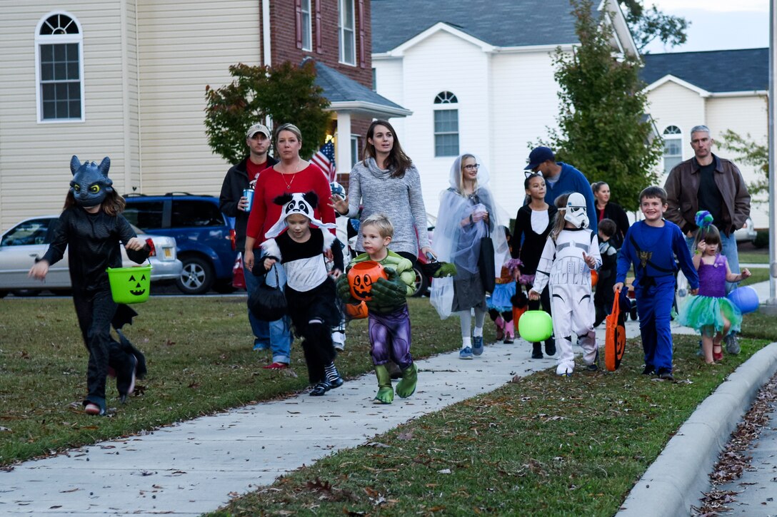 Members of Team Seymour walk through base housing for trick-or-treating, Oct. 31, 2015, at Seymour Johnson Air Force Base, North Carolina. Hundreds of children flooded the streets of base housing looking to fill their buckets and bags full of candy. (U.S. Air Force photo/Airman Shawna L. Keyes)
