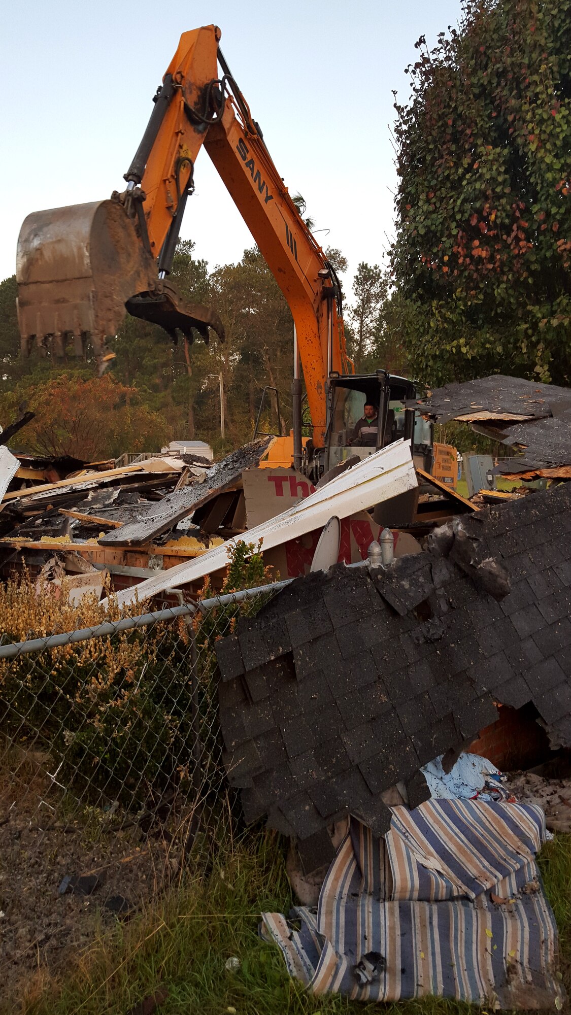An excavator helps clear the wreckage of Joe and Yvonne Mason’s house, Oct. 24, 2015, in Mar-Mac, North Carolina. The house caught fire Oct. 11 and was a complete loss for the family. Their neighbor, Tech. Sgt. Justin Manning, 4th Equipment Maintenance Squadron aerospace ground equipment technician, was one of the first on-scene and has helped the family with the process every step of the way. (Courtesy photo)