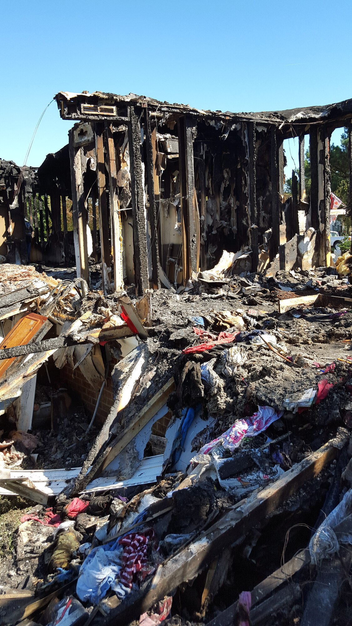 The charred remnants of Joe and Yvonne Mason’s house lay in rubble, Oct. 17, 2015, in Mar-Mac, North Carolina. The house caught fire Oct. 11 and was a complete loss for the family. Their neighbor, Tech. Sgt. Justin Manning, 4th Equipment Maintenance Squadron aerospace ground equipment technician, has helped the family clear the wreckage, even enlisting help from a local business to make the process quicker. (Courtesy photo)