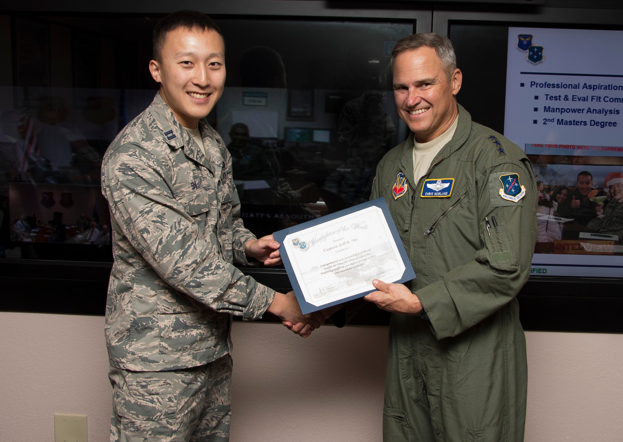 Capt. Jeff Shi, 12th Air Force (Air Forces Southern) operations research analyst, smiles after being presented the Warfighter of the Week from Lt. Gen. Chris Nowland, 12 AF (AFSOUTH) commander, during a staff meeting at Davis-Monthan AFB, Ariz., Oct. 19, 2015. War Fighter of the Week is an opportunity for the Airmen who represent 12th Air Force (Air Forces Southern) to share their own story. The Warfighter of the Week initiative aligns with the 12th Air Force (Air Forces Southern) commander’s priority of creating a work environment where someone knows you both professionally and personally. (U.S. Air Force photo by Staff Sgt. Adam Grant/Released)