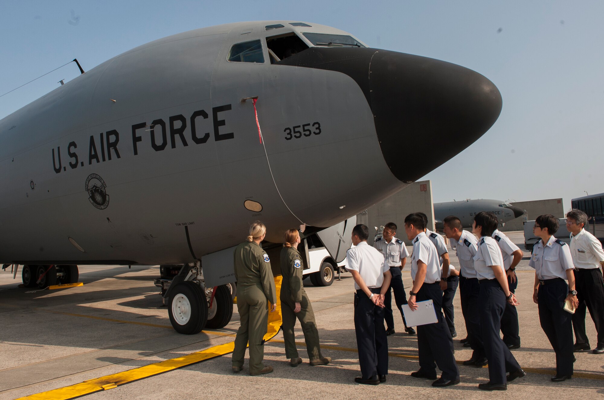 U.S. Air Force Capt. Roberta Parker and 1st Lt. Morgan Bielecki, 909th Air Refueling Squadron pilots, take a group of Japan Air Self-Defense Force members around a KC-135 Stratotanker during a tour Oct. 29, 2015, at Kadena Air Base, Japan. JASDF members visited the 909th ARS to learn about their mission and capabilities. (U.S. Air Force photo by Airman 1st Class Corey M. Pettis)