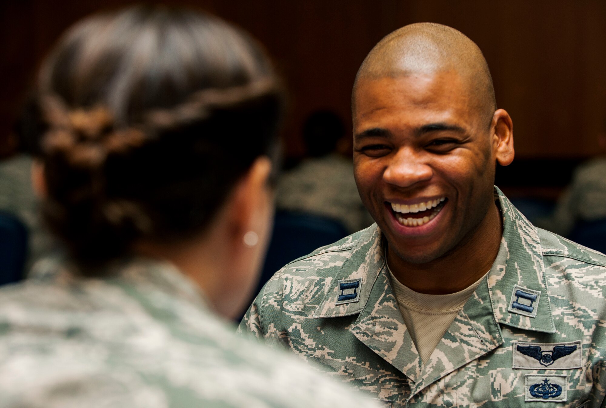 U.S. Air Force Capt. Romaine Russell, 606th Air Control Squadron current operations chief, laughs while talking to his senior NCO counterpart during a speed mentoring session inside Club Eifel at Spangdahlem Air Base, Germany, Oct. 29, 2015. The event took more than 50 minutes, with company grade officers moving around the table and meeting a different SNCO after two minutes of talking and sharing. (U.S. Air Force photo by Airman 1st Class Timothy Kim/Released)