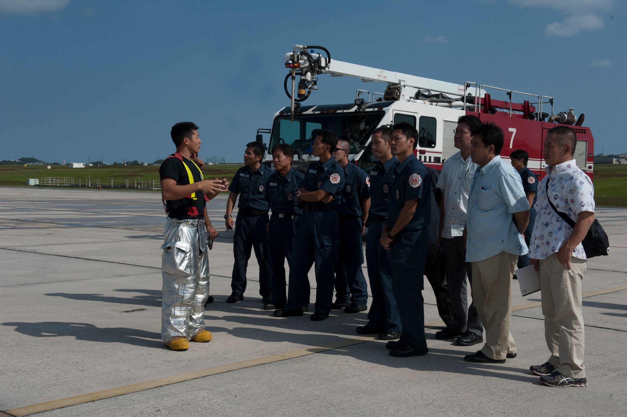 Yuhei Tajima, 18th Civil Engineer Squadron firefighter, speaks to local Okinawan emergency responders during a bilateral aircraft egress training event Oct. 29, 2015, at Kadena Air Base, Japan. During the training, Tajima explained how the 18th CES would response in the event of an aircraft mishap and how developing the relationship between members from the 18th CES and local Okinawan emergency responders is vital to ensuring that both the base and local community are safe. (U.S. Air Force photo by Airman 1st Class Lynette M. Rolen)
