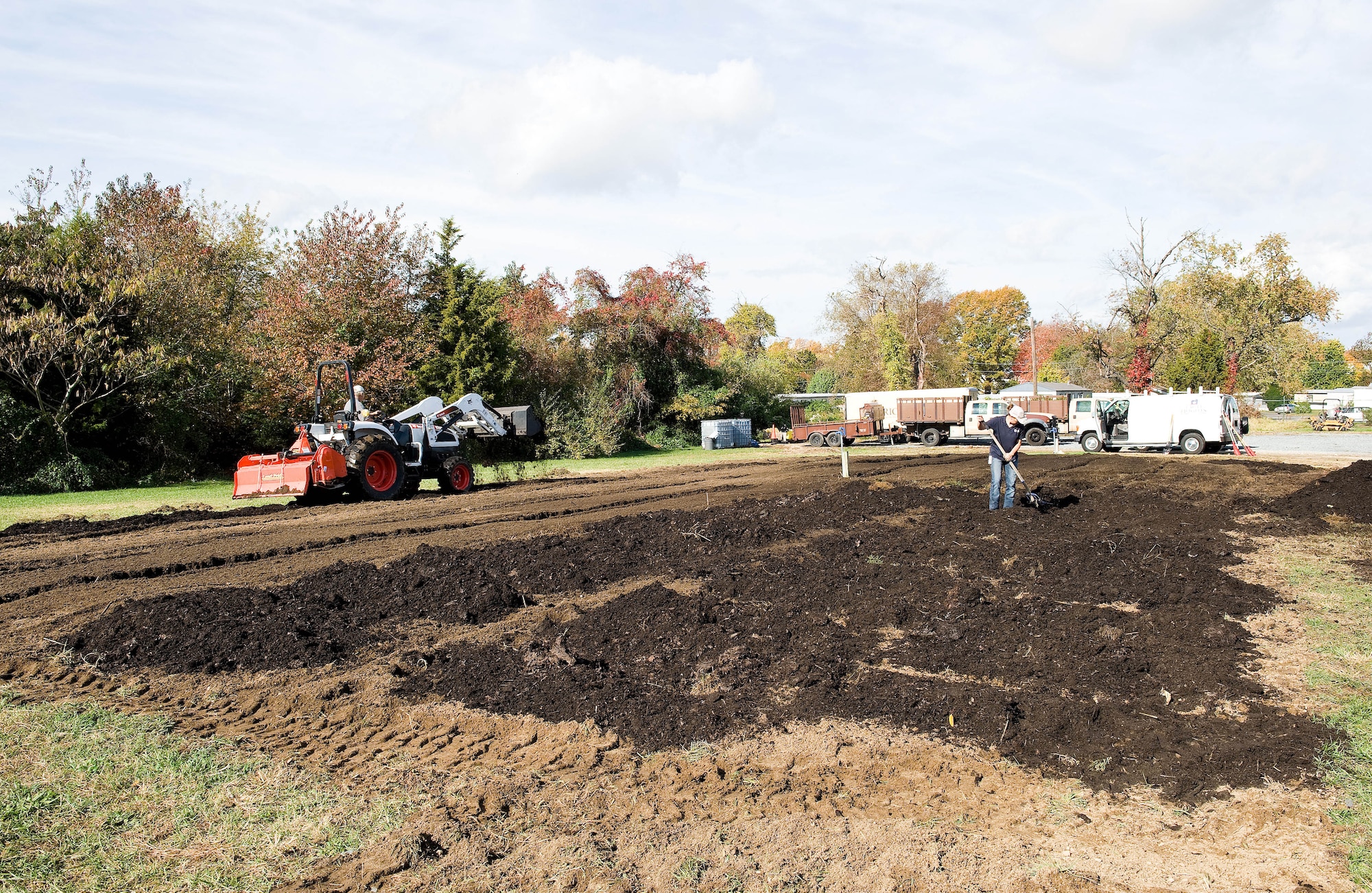 John Clendaniel, Delaware State University College of Agriculture and Related Sciences farm management specialist, left, and Andrea Keen, Delaware Division of Public Health, Kent County Health Unit clinic manager, work leaf mulch into the soil at the community garden Oct. 29, 2015, on Dover Air Force Base, Del. Keen stated the Dover AFB community garden is the second largest of four community gardens she is involved with, measuring 60-feet-wide by 120-feet-long. (U.S. Air Force photo/Roland Balik)