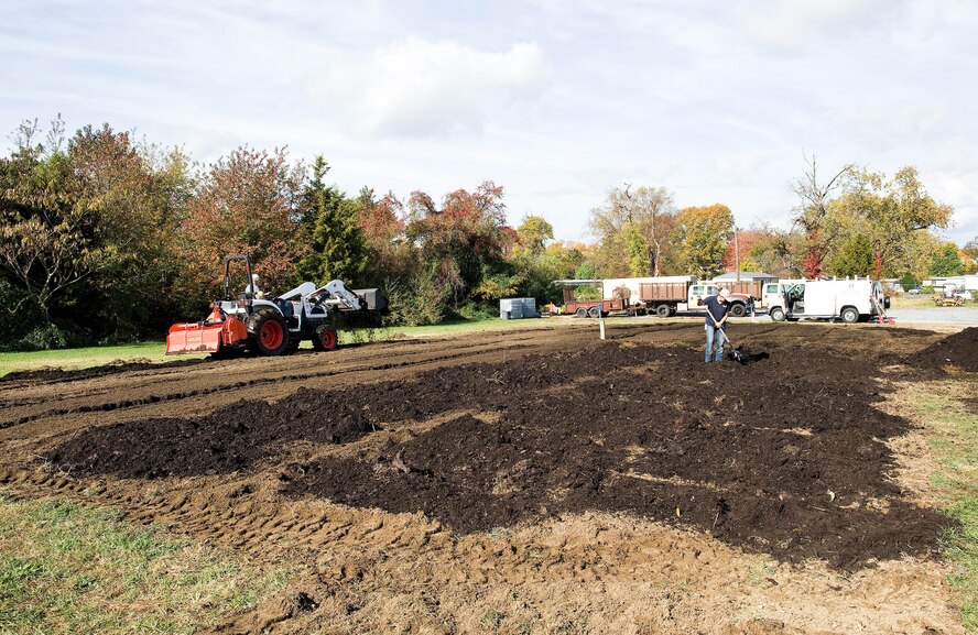 John Clendaniel, Delaware State University College of Agriculture and Related Sciences farm management specialist, left, and Andrea Keen, Delaware Division of Public Health, Kent County Health Unit clinic manager, work leaf mulch into the soil at the community garden Oct. 29, 2015, on Dover Air Force Base, Del. Keen stated the Dover AFB community garden is the second largest of four community gardens she is involved with, measuring 60-feet-wide by 120-feet-long. (U.S. Air Force photo/Roland Balik)