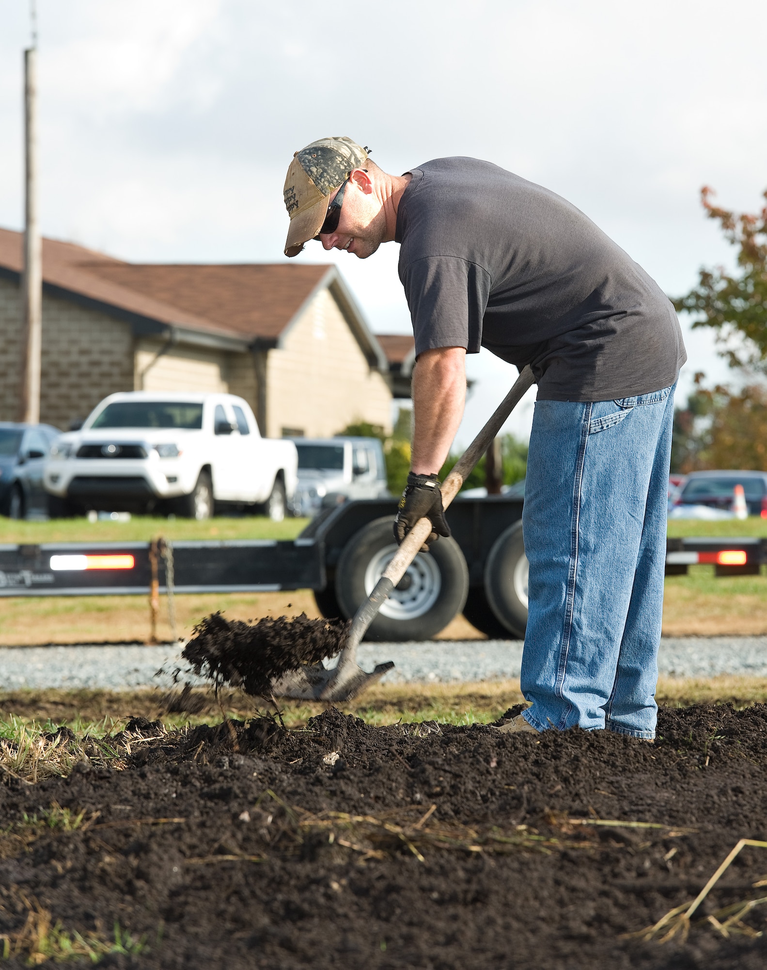 Tech. Sgt. John Maynard, 436th Dental Squadron dental lab flight chief, spreads donated leaf mulch Oct. 29, 2015, at the new organic community garden on Dover Air Force Base, Del. Maynard, a resident of Eagle Heights family housing and a garden enthusiast, volunteered to work in and monitor the garden to ensure the success of this Air Force Community Partnership Program P4 initiative. (U.S. Air Force photo/Roland Balik)