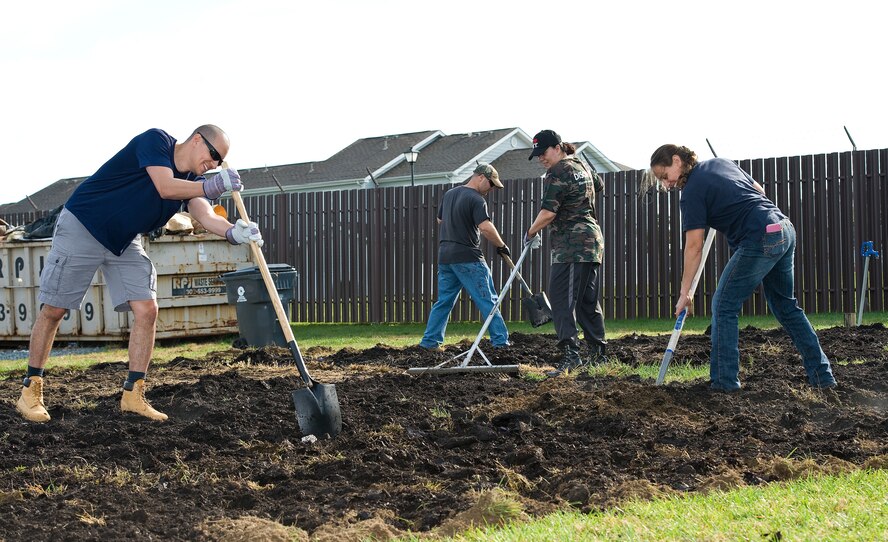 Tech. Sgts. Victor Carmona, clinical flight chief, and John Maynard, dental lab flight chief, both from the 436th Dental Squadron and residents of Eagle Heights family housing; Sophia Reeves, Hunt Companies, Inc., Military Housing Communities, Dover AFB community director; and Andrea Keen, Delaware Division of Public Health, Kent County Health Unit, clinic manager; left to right respectively, spread donated leaf mulch from the City of Dover, Del., at the new organic community garden Oct. 29, 2015, on Dover Air Force Base, Del. Team Dover Air Force Community Partnership Program P4 community garden initiative stakeholders and volunteers helped spread the mulch, tilled it into the soil and planted seeds for a winter cover crop of wheat rye in preparation for the first of three plantings beginning in February 2016. (U.S. Air Force photo/Roland Balik)