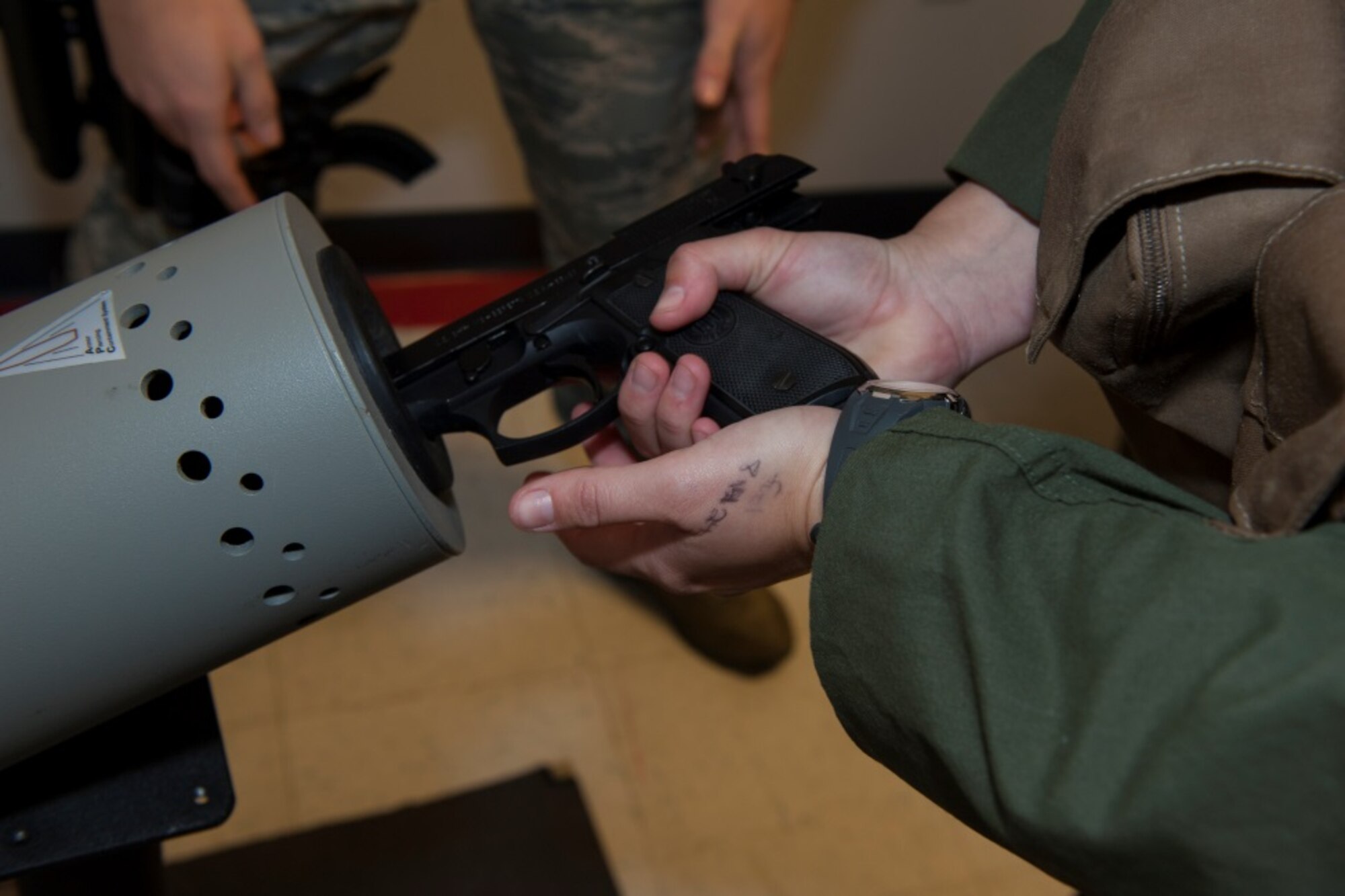 A Minot pilot arms his weapon with dummy rounds during training at Minot Air Force Base, N.D., Oct. 30, 2015. The aircrew flight equipment shop trains pilots in arming and disarming safely for upcoming exercises. (U.S. Air Force photo/Airman 1st Class Christian Sullivan)