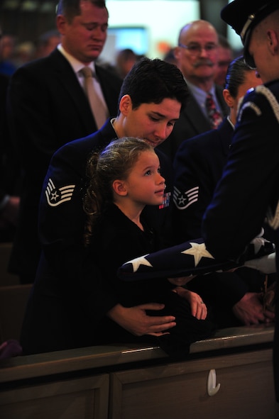 Sophia Gonzalez receives a folded flag from an honor guard member during the funeral of her father, Master Sgt. Matthew Gonzalez, at Minot Air Force Base, N.D., Oct. 26, 2015. Four-year-old Sophia, who was referred to as “Sophia Bear” by her late father, was Gonzalez’s only child. (U.S. Air Force photo/Senior Airman Stephanie Morris)