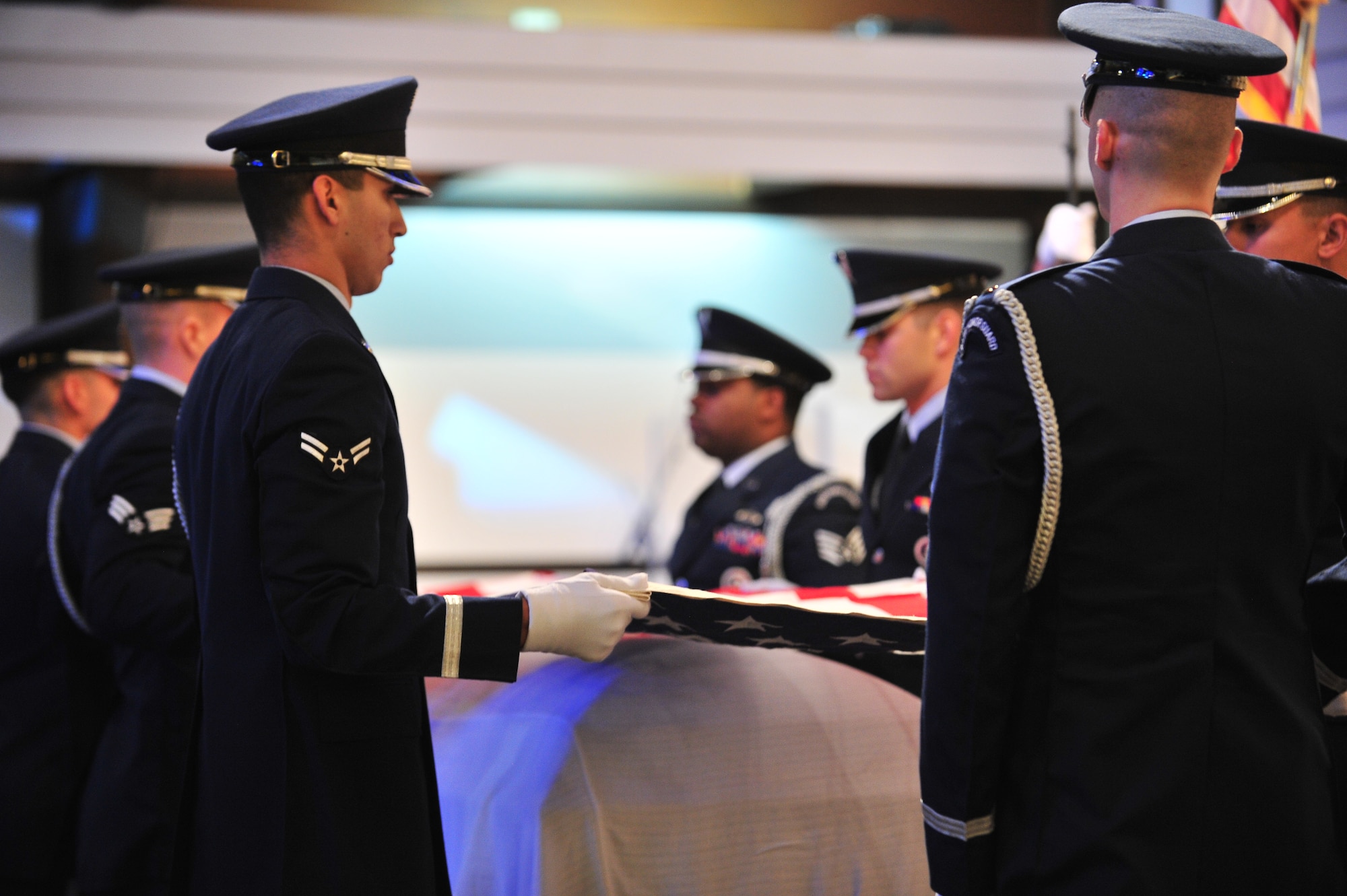 Honor guard members fold a flag over the casket of Master Sgt. Matthew Gonzalez during his funeral at Minot Air Force Base, N.D., Oct. 26, 2015. Gonzalez was born January 26, 1979, in Neenah, Wis. and enlisted in the Air Force in September 1997. (U.S. Air Force photo/Senior Airman Stephanie Morris)