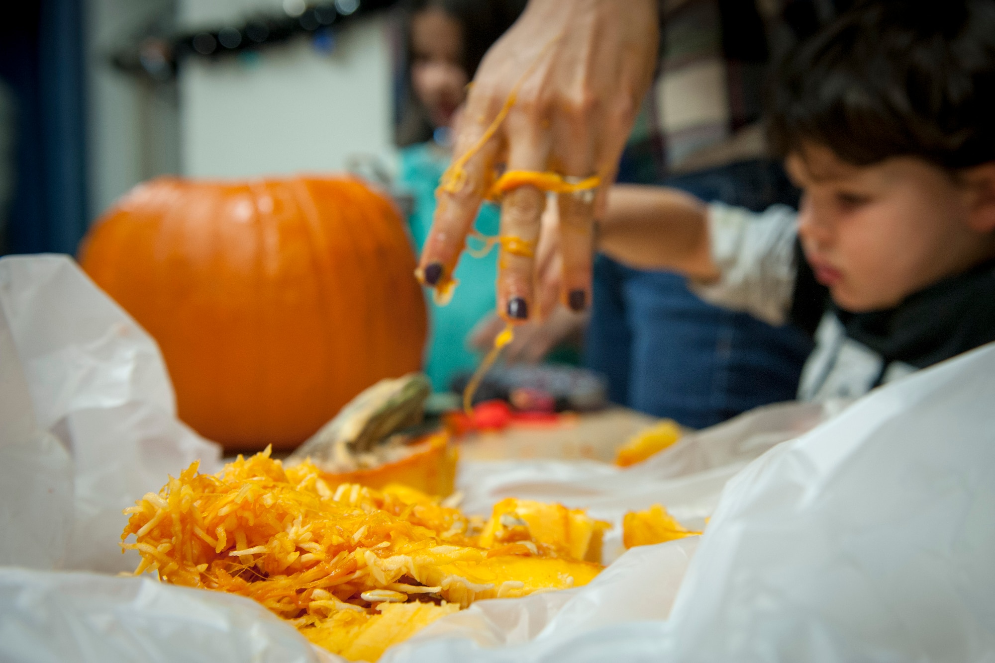 PETERSON AIR FORCE BASE, Colo. -- Tricia Taiclet, Air Force spouse, works with her son, Carson, to clean out a pumpkin before carving it at Patriot Hall, Oct. 28, 2015. They were there for the Peterson Chapel's 3rd Annual Pumpkin Carving Contest, where carving tools, pumpkins and candy were provided by the chapel. (U.S. Air Force photo by Senior Airman Rose Gudex)