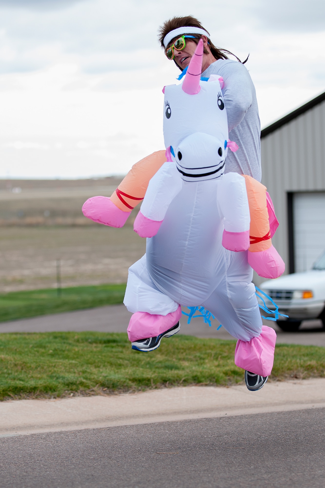 PETERSON AIR FORCE BASE, Colo. - Master Sgt. Eric Buys, 21st Operations Group, hangs on as his unicorn leaps for joy during the 21st Space Wing Warfit fun run Oct. 30, 2015. The 5K run started at The Club on Peterson Air Force Base and followed a trail around the golf course and finished back at The Club. Participants also had the opportunity to take part in the Final Friday activities after the run. (U.S. Air Force photo by Craig Denton)