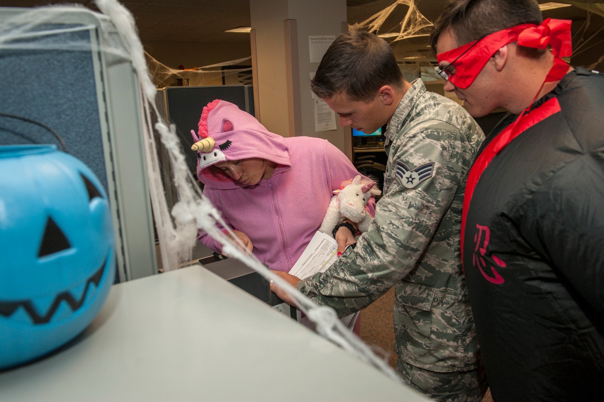 PETERSON AIR FORCE BASE, Colo. -- Airmen from the 21st Comptroller Squadron dressed up in their Halloween best to celebrate the holiday a day early Oct. 30, 2015. They went about their jobs as if it were any other normal day, including assisting customers. Costumes not only boosted their own morale, but the spirits of customers coming to the finance office. (U.S. Air Force photo by Senior Airman Rose Gudex)