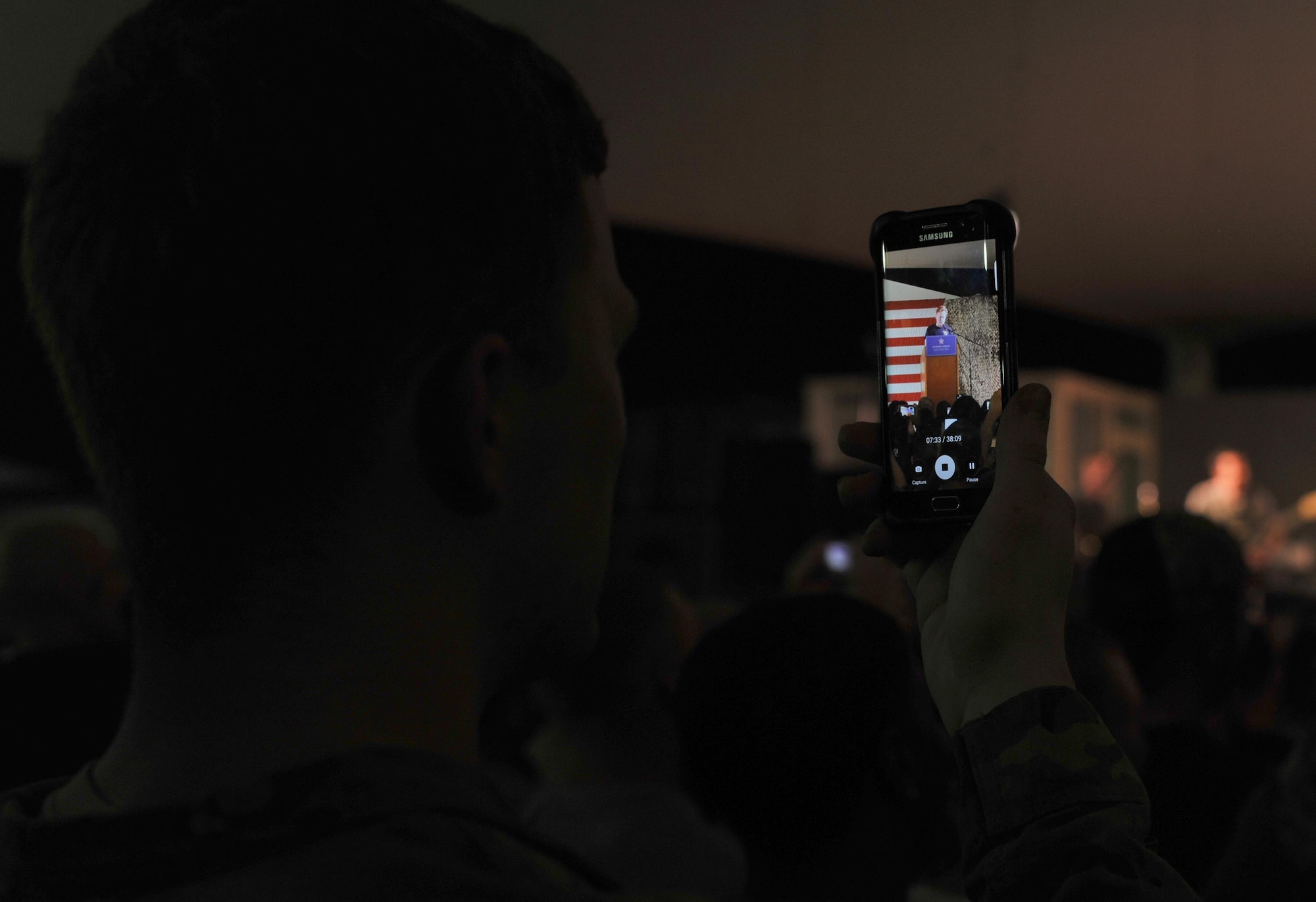 A member of the audience records a comic set by Conan O'Brien during an event at Al Udeid Air Base, Qatar, Nov. 3, 2015. The event consisted of O'Brien serving as host to a group of comedians and musical guest Grace Potter. (U.S. Air Force photo by Tech. Sgt. Joshua Strang)