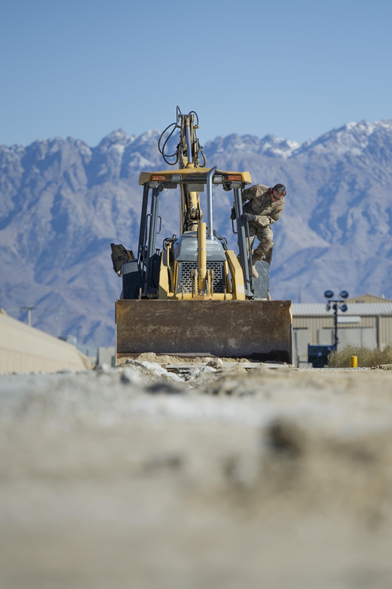 Tech. Sgt. David Blankenship, 455th Expeditionary Civil Engineer Squadron pavements and equipment technician, deployed from the 2nd CES at Barksdale Air Force Base, La., inspects his backhoe at Bagram Airfield, Afghanistan, Nov. 4, 2015. The 455th ECES "Dirt Boys" prepared an area for cement in support of a large-area maintenance structure slated for construction in the next few months. (U.S. Air Force photo by Tech. Sgt. Robert Cloys/RELEASED)