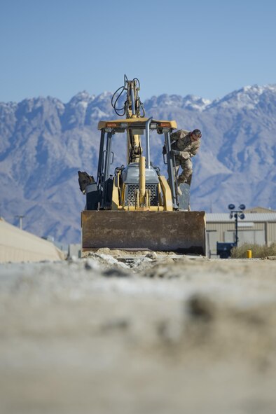 Tech. Sgt. David Blankenship, 455th Expeditionary Civil Engineer Squadron pavements and equipment technician, deployed from the 2nd CES at Barksdale Air Force Base, La., inspects his backhoe at Bagram Airfield, Afghanistan, Nov. 4, 2015. The 455th ECES "Dirt Boys" prepared an area for cement in support of a large-area maintenance structure slated for construction in the next few months. (U.S. Air Force photo by Tech. Sgt. Robert Cloys/RELEASED)