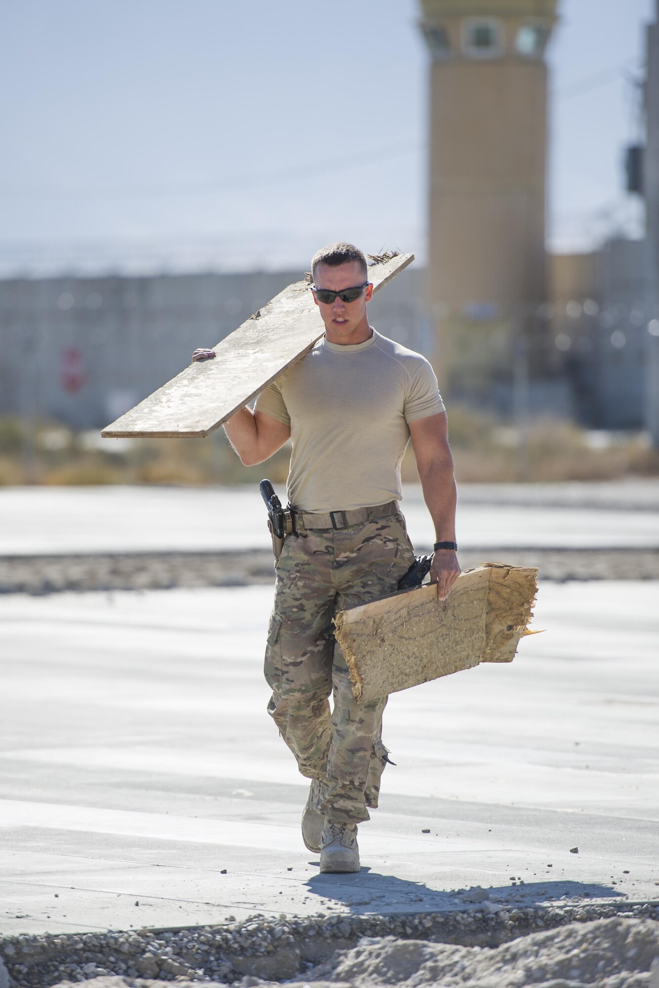 Airman 1st Class Patrick Chuba, 455th Expeditionary Civil Engineer Squadron pavements and equipment technician, deployed from the 2nd CES at Barksdale Air Force Base, La., carries scrap wood to a construction site at Bagram Airfield, Afghanistan, Nov. 4, 2015. The "Dirt Boys" prepared an area for cement in support of a large-area maintenance structure slated for construction in the next few months.(U.S. Air Force photo by Tech. Sgt. Robert Cloys/RELEASED)