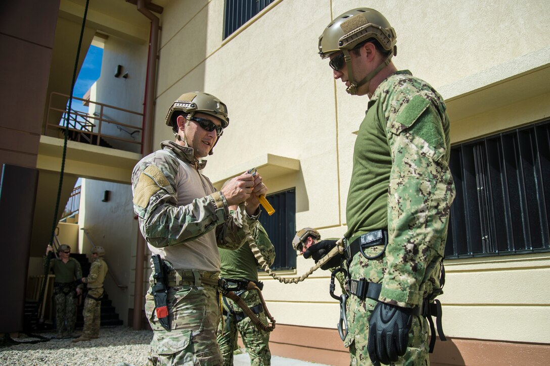 Sailors check their equipment before participating in helicopter rope suspension technique training on Naval Base Guam, Oct. 29, 2015.  U.S. Navy photo by Petty Officer 2nd Class Daniel Rolston