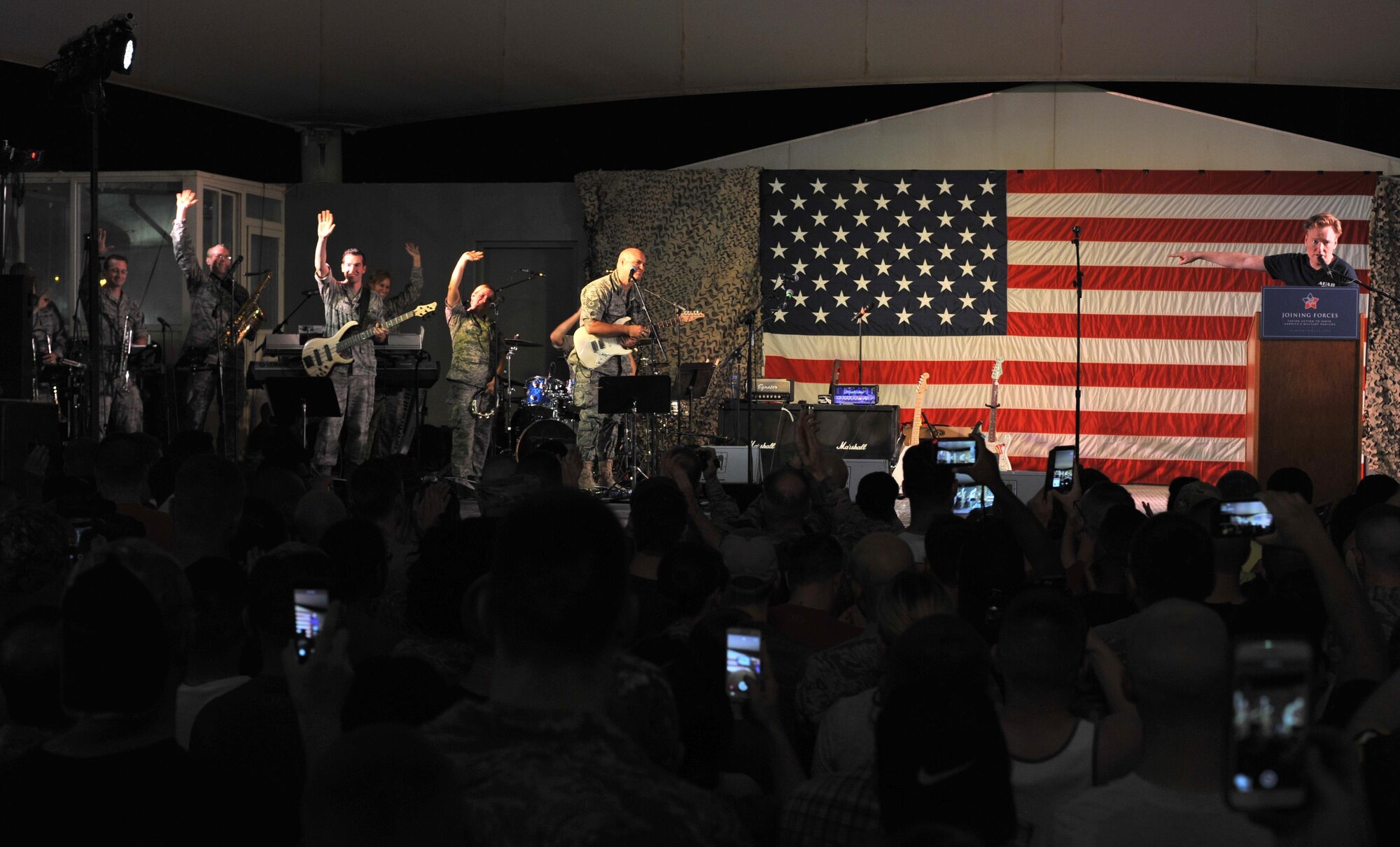 Conan O'Brien, O'Brien's house band leader Jimmy Vivino, Grace Potter, and the U.S. Air Forces Central Command band play together during an event at Al Udeid Air Base, Qatar, Nov. 3, 2015. The band served as the house band during the event as well as providing backup for Potter. (U.S. Air Force photo/Tech. Sgt. Joshua Strang)